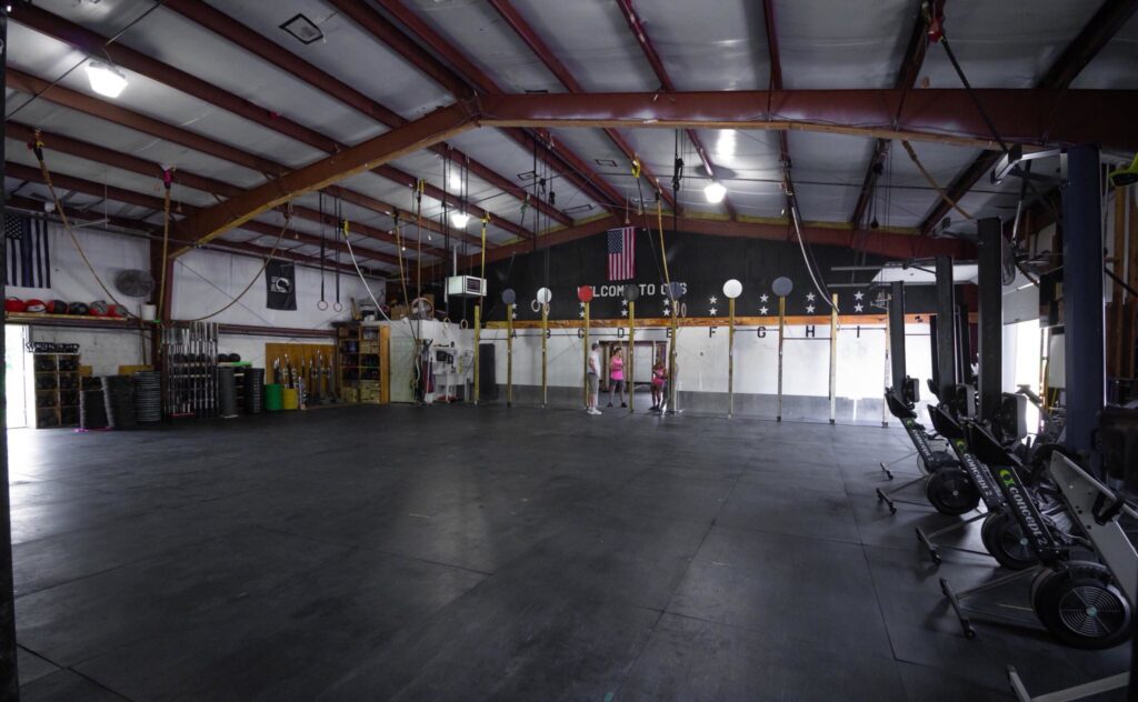 The gym floor's pull-up rig, with MOVE WITH PURPOSE painted on the far wall