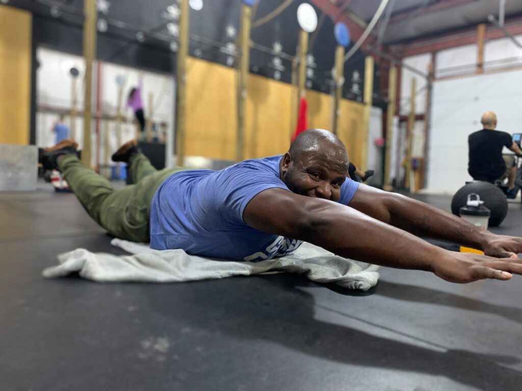 A member holding a floor stretch during class
